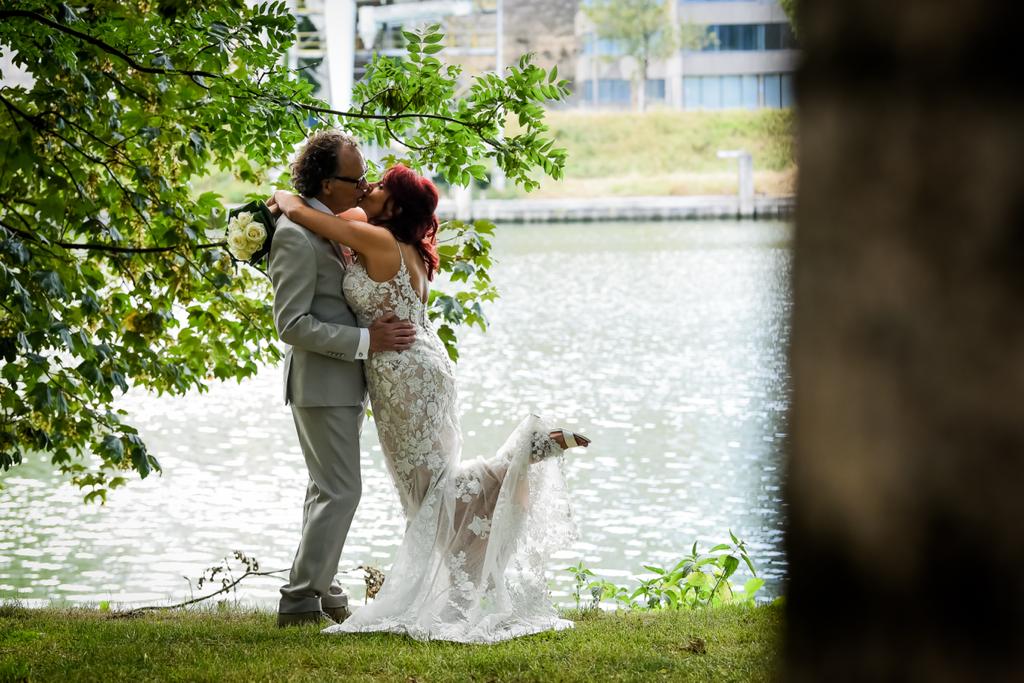 Foto bruid in kanten jurk kust haar bruidegom
